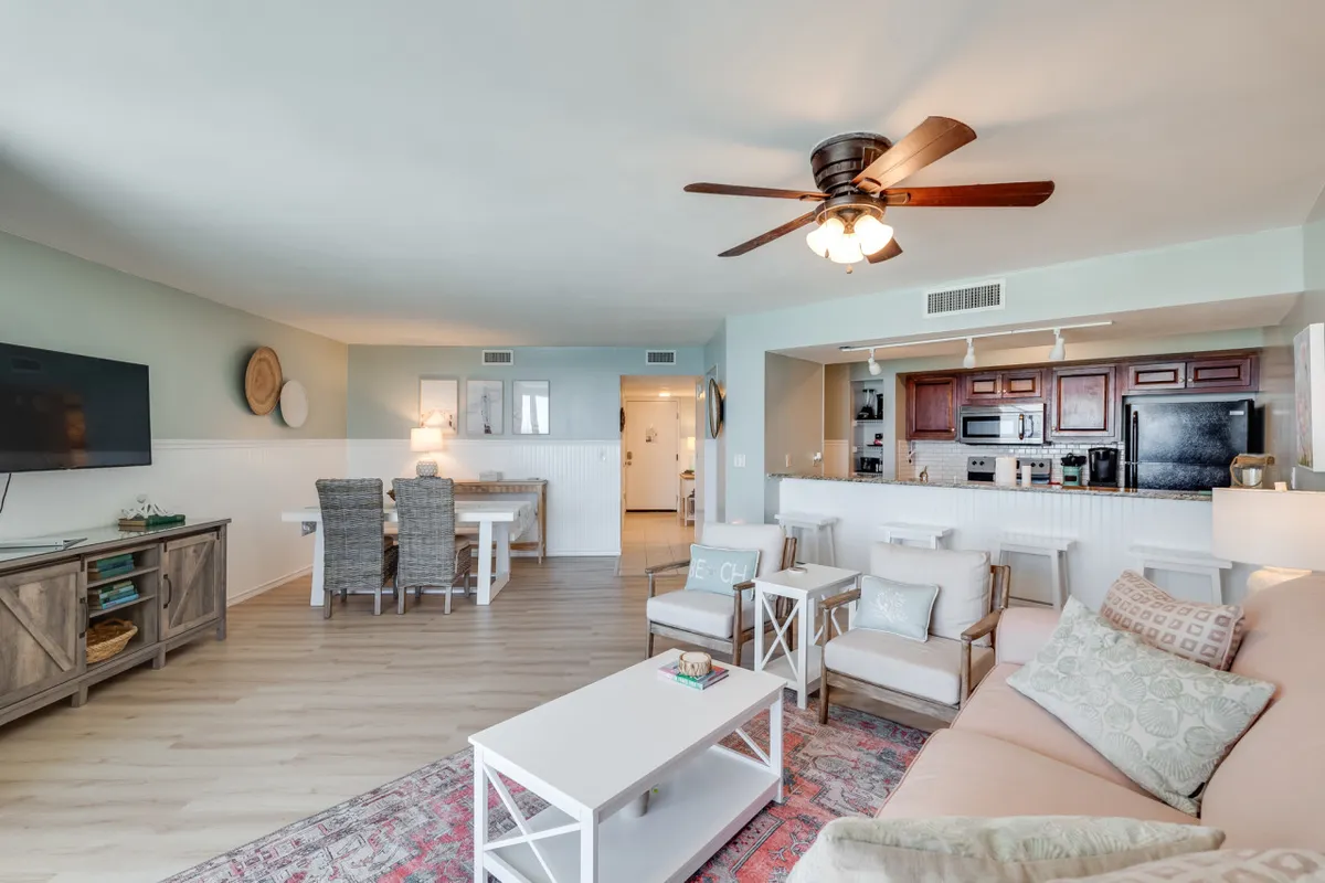 A comfortable living area with a sofa, dining table, television, and kitchen bar. The space is designed for relaxation and can accommodate flexible sleeping arrangements, such as a queen sleeper sofa for guests.