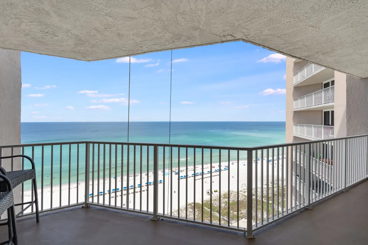 An elevated view from a private balcony, looking out over the Gulf’s turquoise waters, white sandy beaches, and the balcony’s comfortable seating area. The tranquil ocean backdrop provides a sense of relaxation after a day filled with activity.