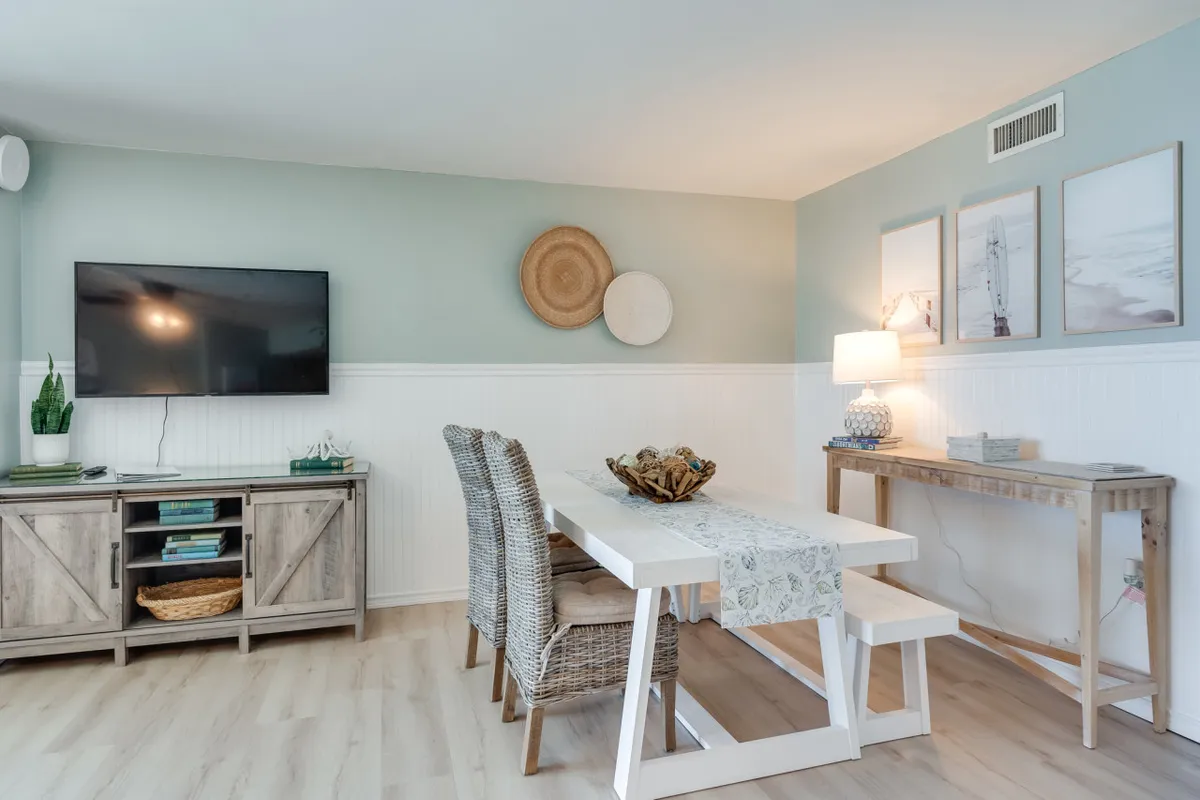 A cozy interior scene centered on a dining table set for family meals, with a television, wall art, and soft lighting creating a welcoming space for gatherings and shared laughter.